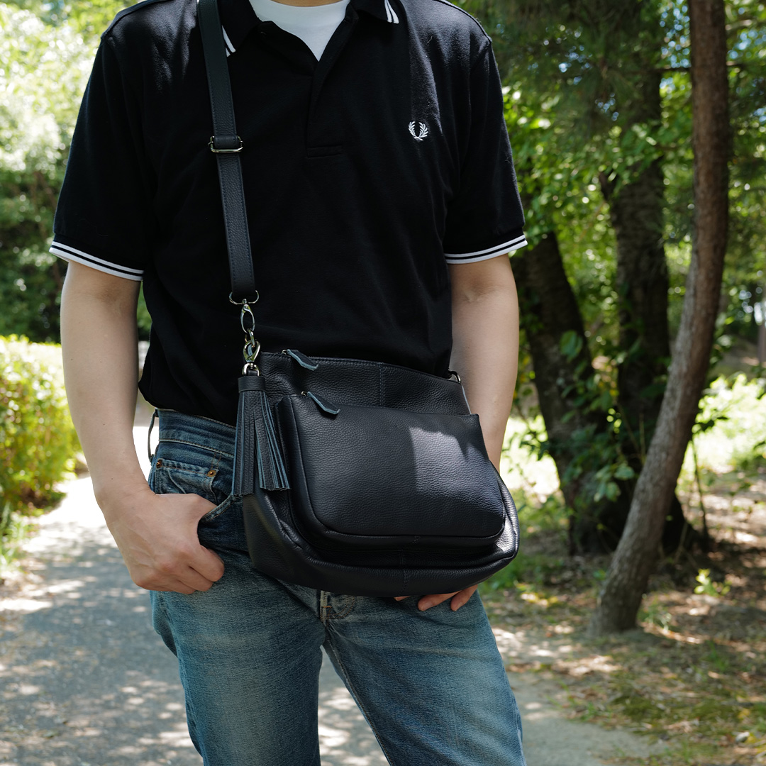 夏の涼しげな木陰が映える50代の本革ショルダーバッグ（斜めがけスタイル）